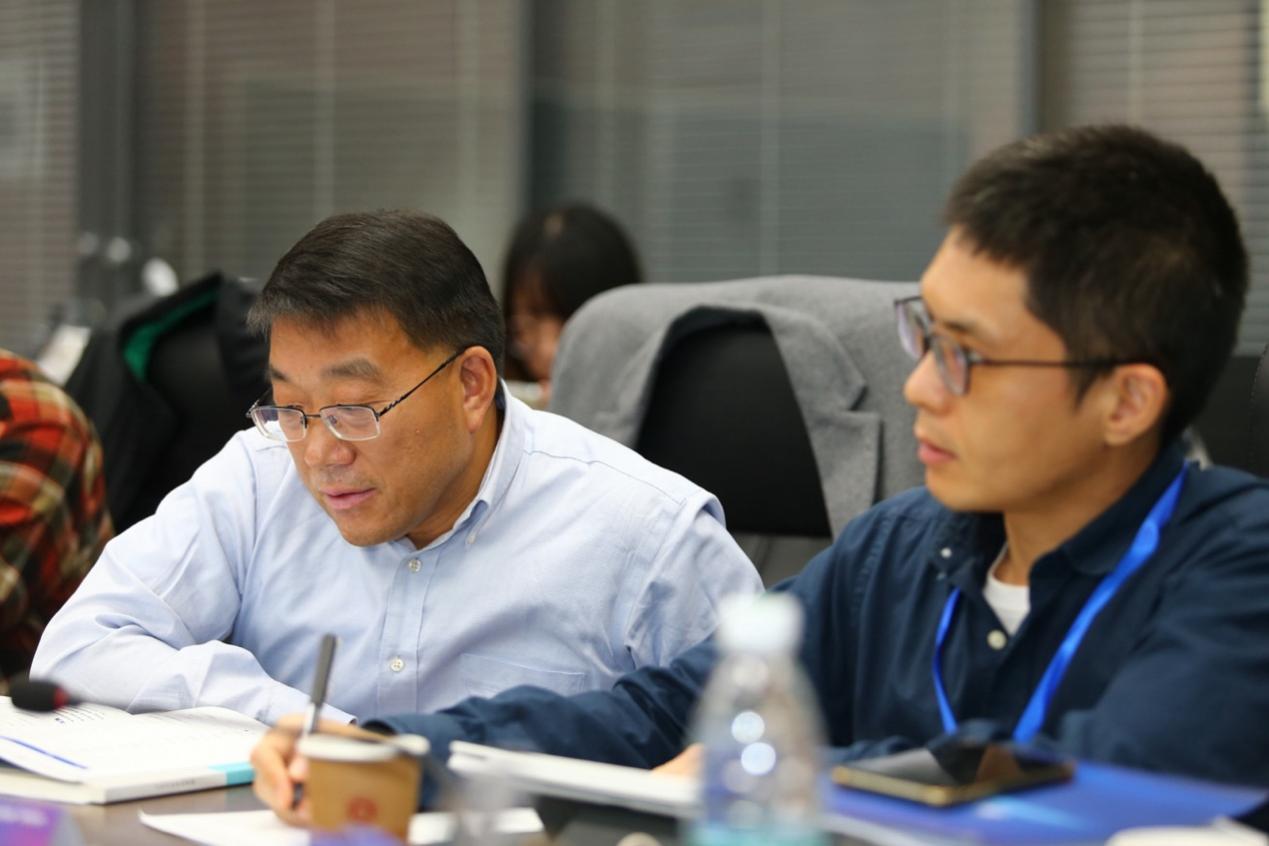 一群人看着桌子上的电脑描述已自动生成 一群人看着桌子上的电脑描述已自动生成