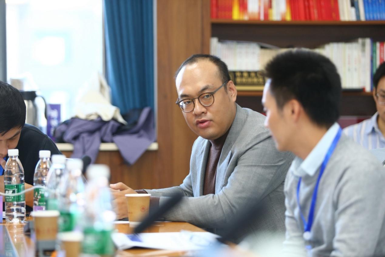 一群人坐在桌子前描述已自动生成 一群人坐在桌子前描述已自动生成